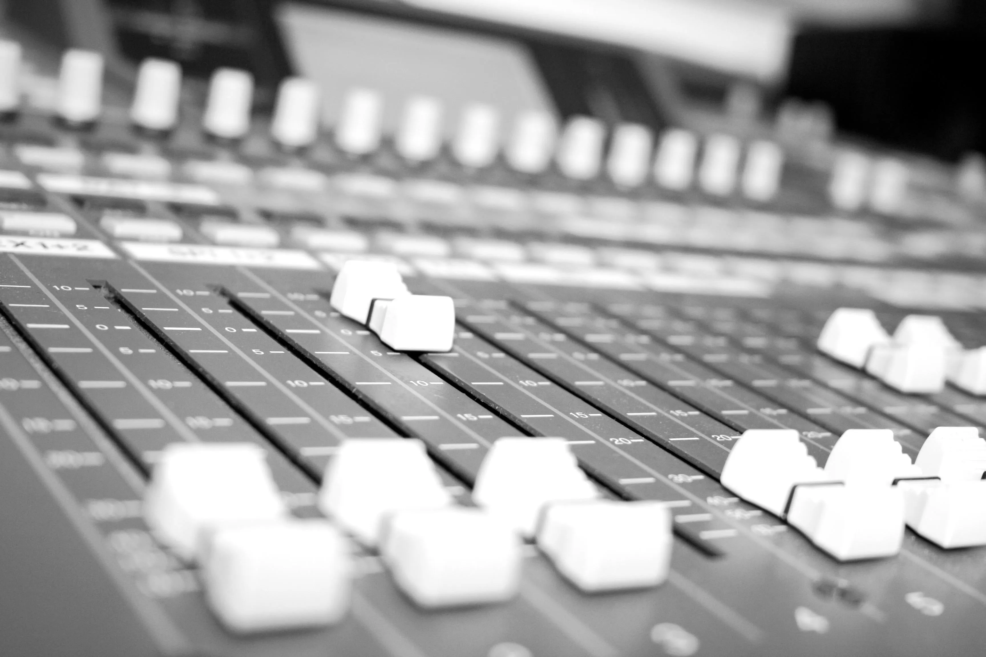 Nahaufnahme der Fader eines Mischpults im Tonstudio